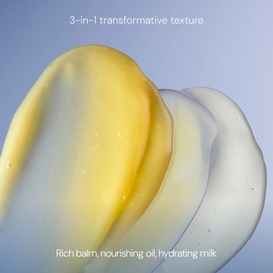 Three smooth, translucent product textures layered diagonally on a soft blue gradient background, with text reading '3-in-1 transformative texture' at the top and 'Rich balm, nourishing oil, hydrating milk' at the bottom.